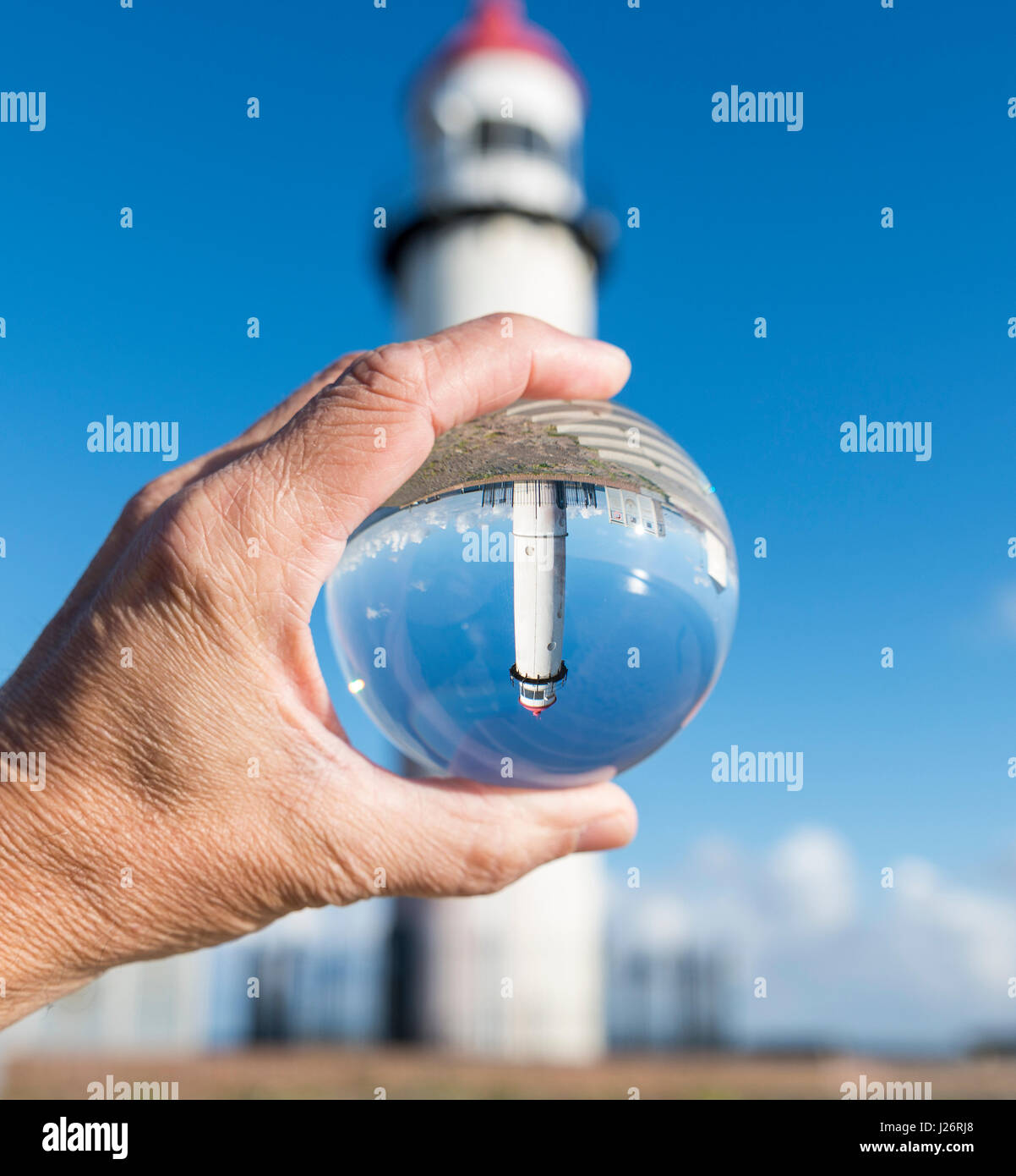Sfera di vetro con hellevoetsluis faro visto con cielo blu sullo sfondo Foto Stock