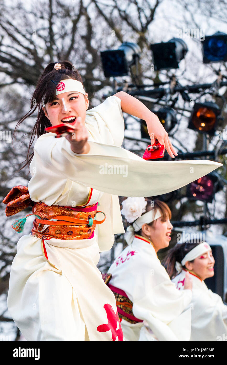 Hinokuni Yosakoi Dance Festival di Kumamoto. Le donne giapponesi che danzano sul palco. Indossare uno yukata bianco con anta rosso e tenendo naruko, battagli. Foto Stock