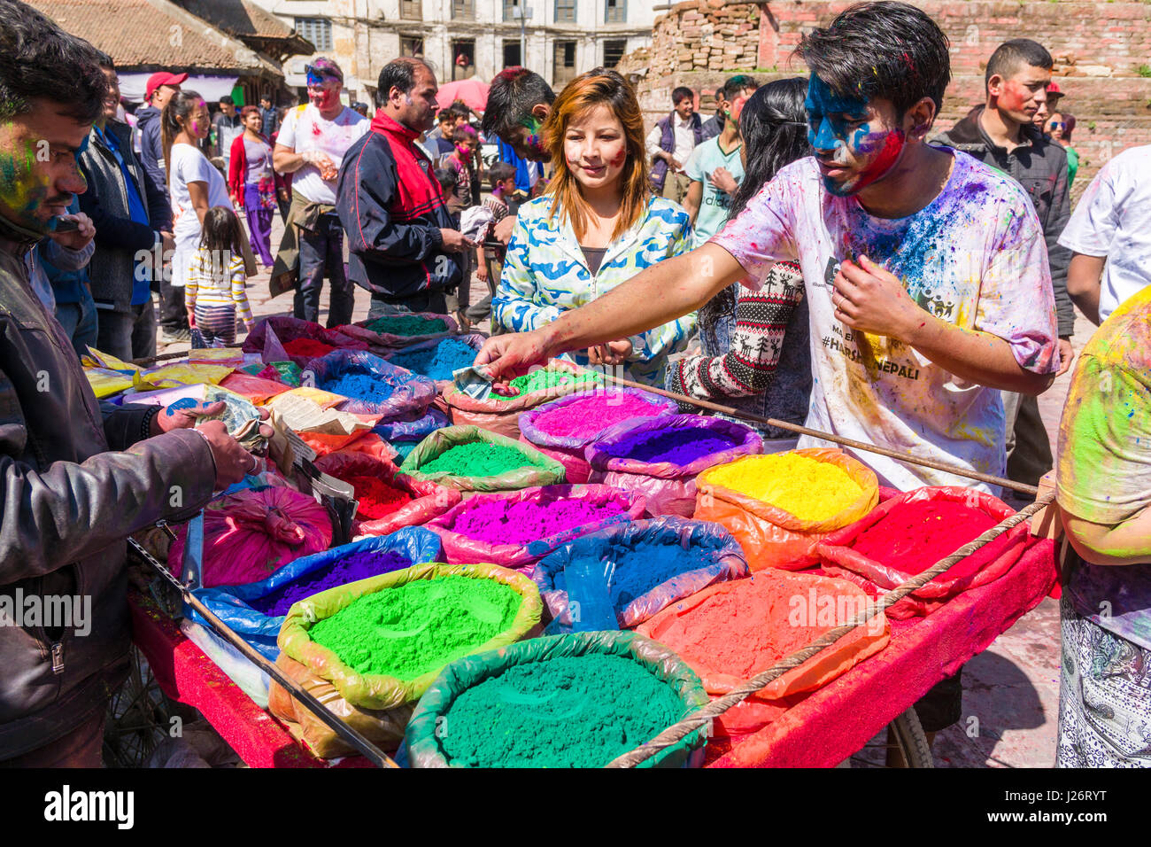 Un giovane uomo, cosparse di colore, è di acquistare il colore in polvere per la Holi festival Foto Stock