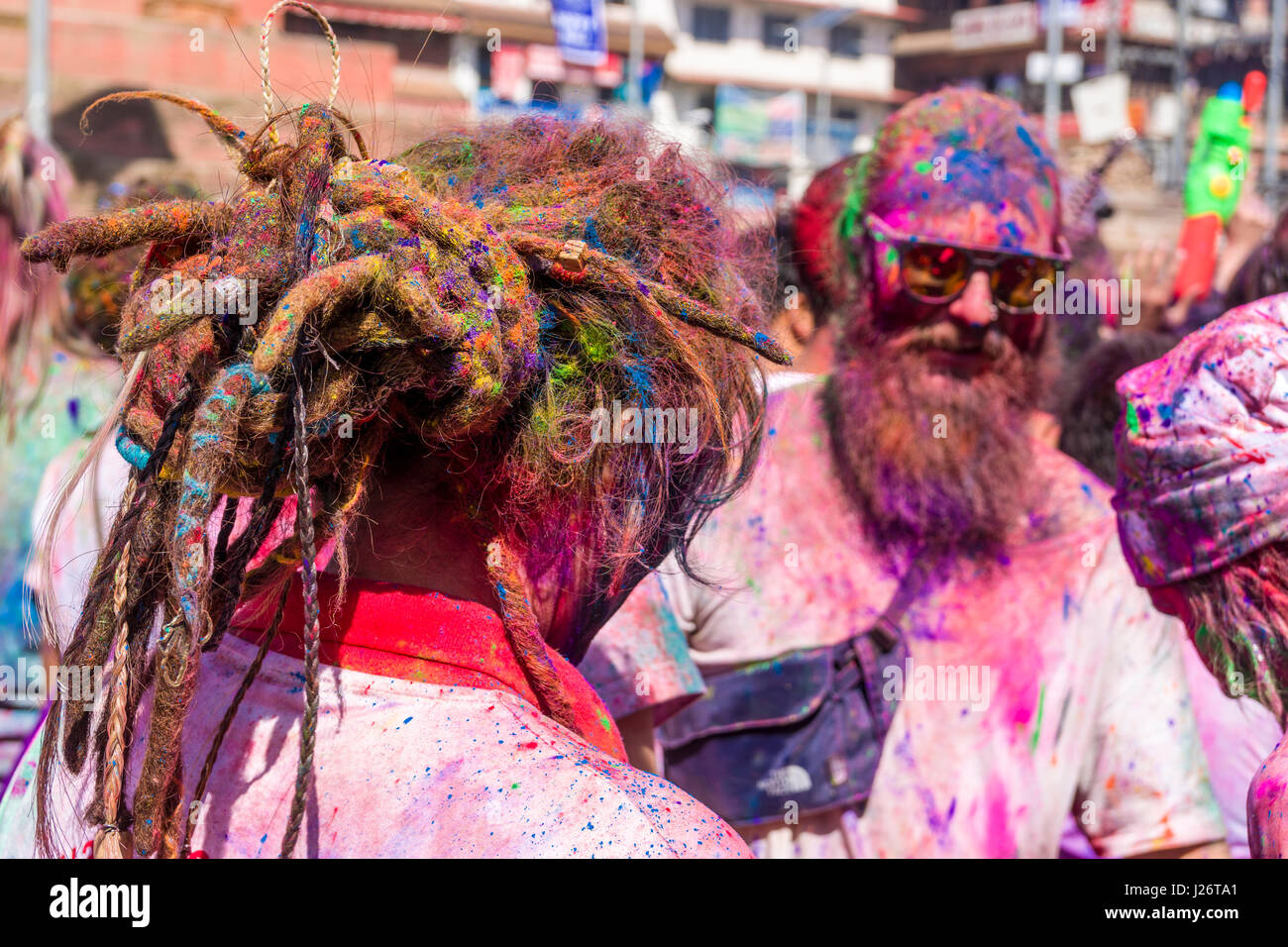 I turisti occidentali tra migliaia di giovani, macchie e a giocare con i colori, celebrano la Holi festival Foto Stock