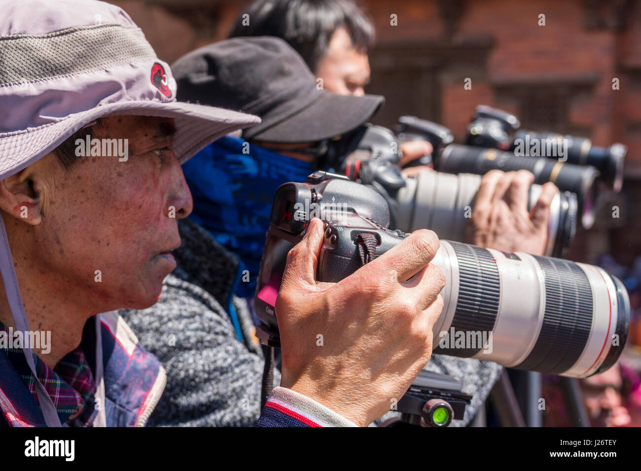 I turisti cinesi stanno prendendo fotografie di migliaia di giovani, cosparse e a giocare con i colori, celebrando la Holi festival Foto Stock