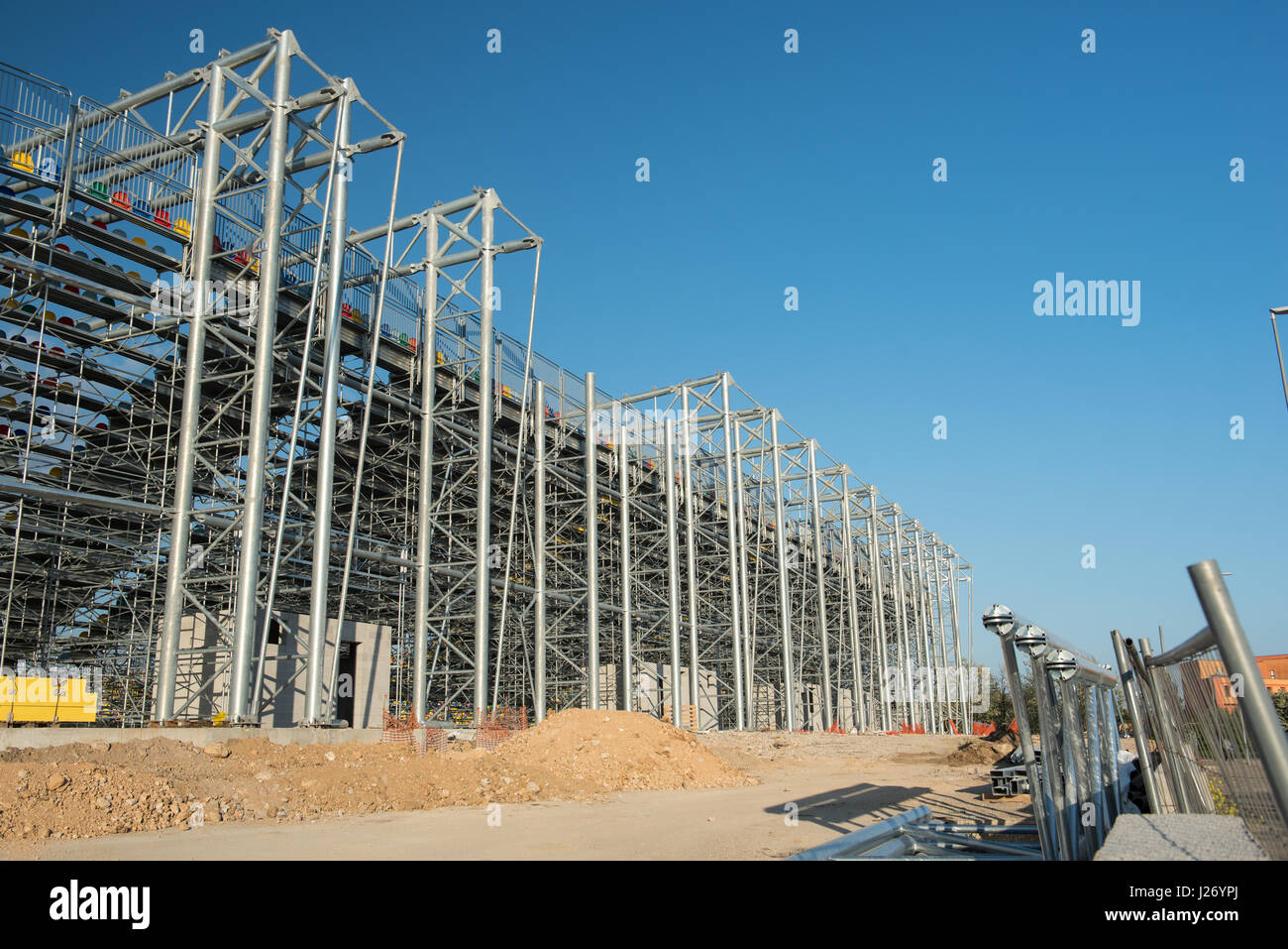 Frosinone, Italia 23 Aprile 2017: vista esterna dello stadio di calcio in costruzione con struttura in acciaio, gradinate e colorati posti sul cielo blu Foto Stock
