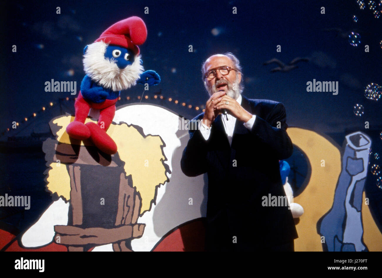 Sänger Niederländischer und Komponist Pierre Kartner, mehr als bekannt Vader Abramo, singt mit Papa Schlumpf 'Dcome Lied der Schlümpfe', Deutschland 1980er jahre. Dutch cantante e compositore Pierre Kartner, aka Vader Abramo, cantando con Grande Puffo 'Dcome Lied der Schlümpfe', Germania degli anni ottanta. Foto Stock