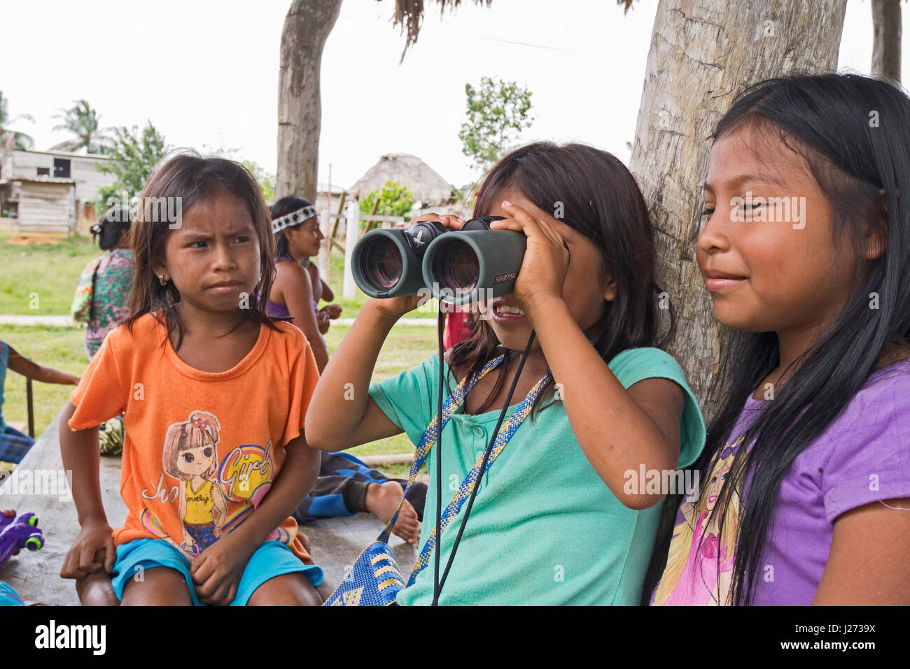 Emberå ragazze al Nuevo Vigia guardando attraverso il binocolo a uccelli Panama Foto Stock