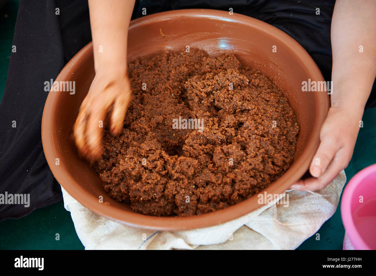 Pasta di Argan essendo miscelati a mano prima di premere l'olio. Cooperativa Marjana, Ounara, Essouira, Marocco Foto Stock