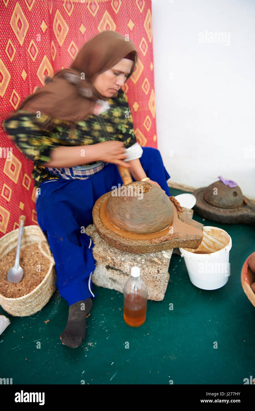 Le donne di fresatura di Argan arrosto dadi presso la cooperativa Marjana, Ounara, Essouira, Marocco Foto Stock