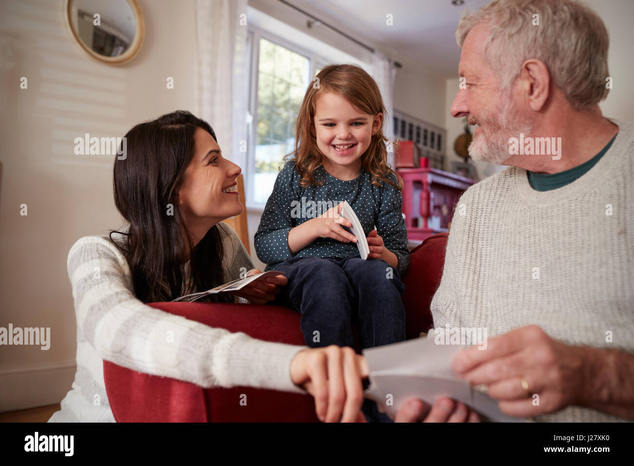 Generazione di più la famiglia a casa guardando le fotografie Foto Stock