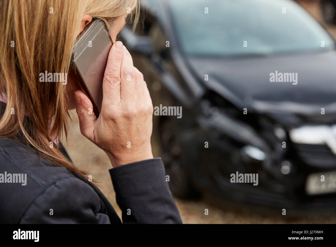 Donna che chiama alla relazione incidente di auto sulla strada di campagna Foto Stock