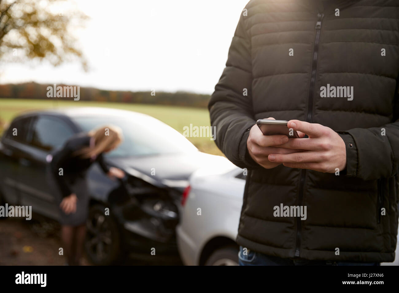 L'uomo chiamando per relazione incidente di auto sulla strada di campagna Foto Stock