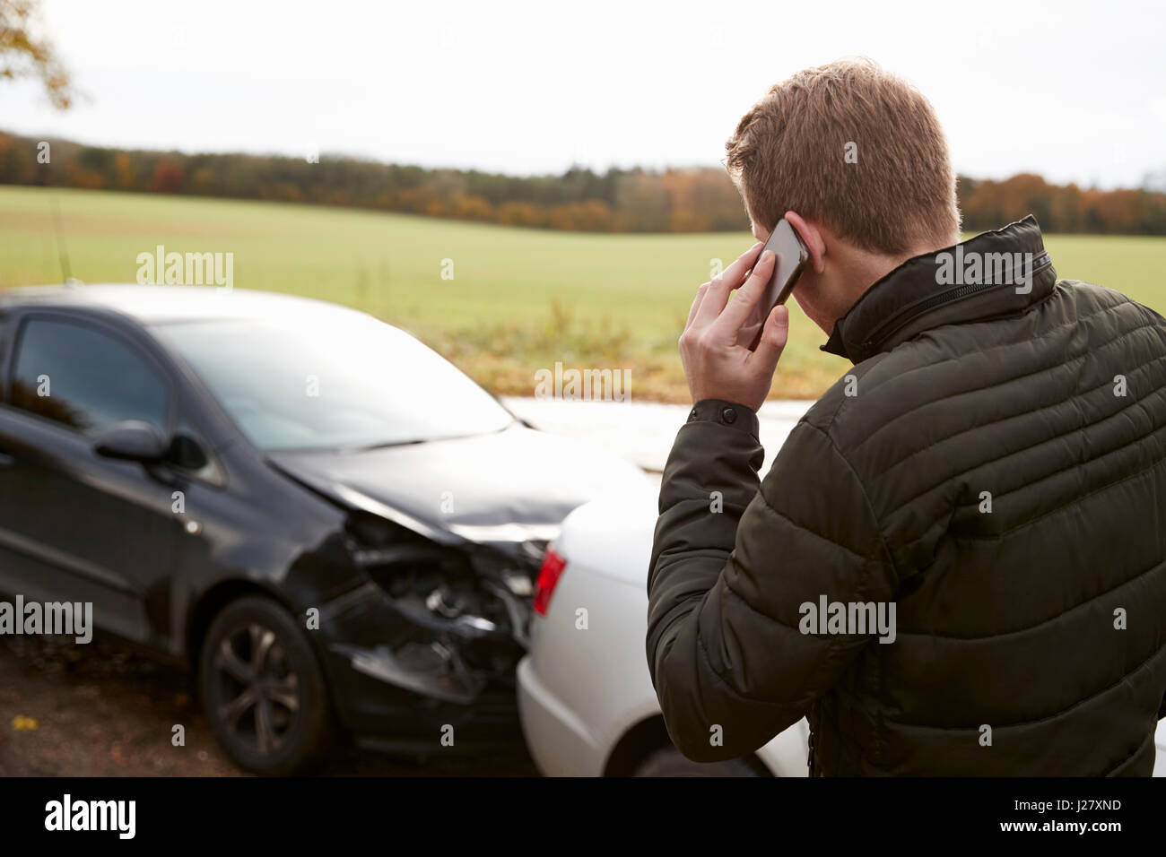 L'uomo chiamando per relazione incidente di auto sulla strada di campagna Foto Stock