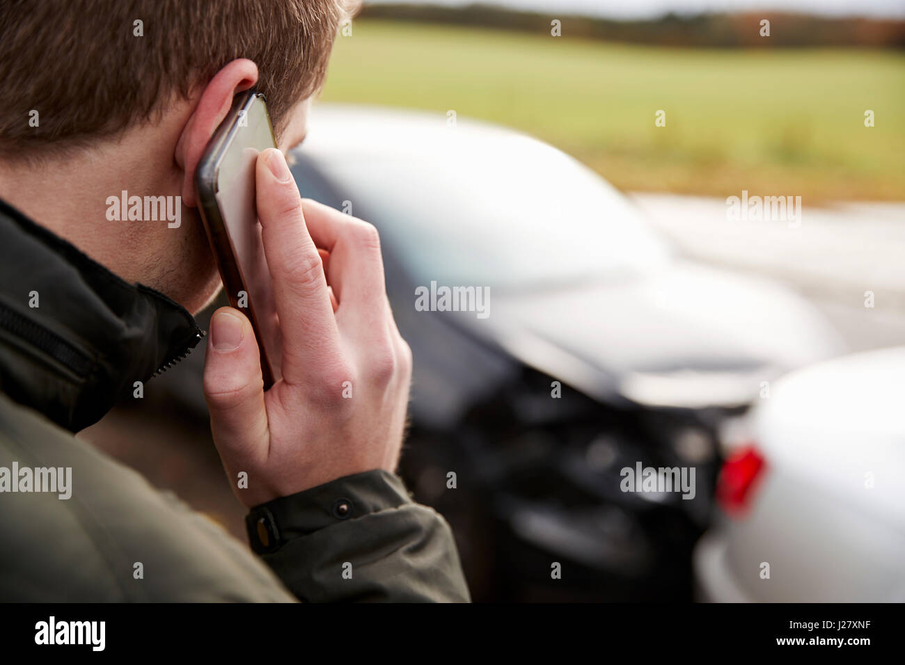 L'uomo chiamando per relazione incidente di auto sulla strada di campagna Foto Stock