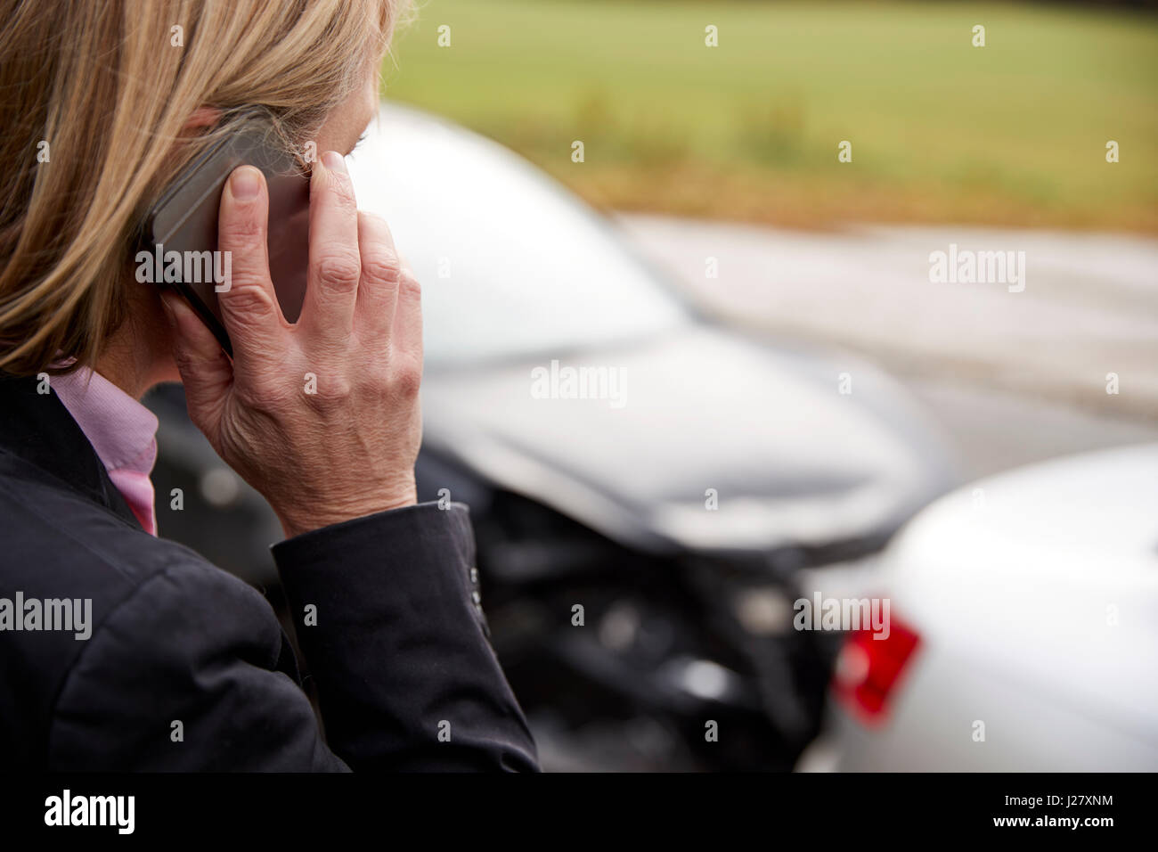 Donna che chiama alla relazione incidente di auto sulla strada di campagna Foto Stock