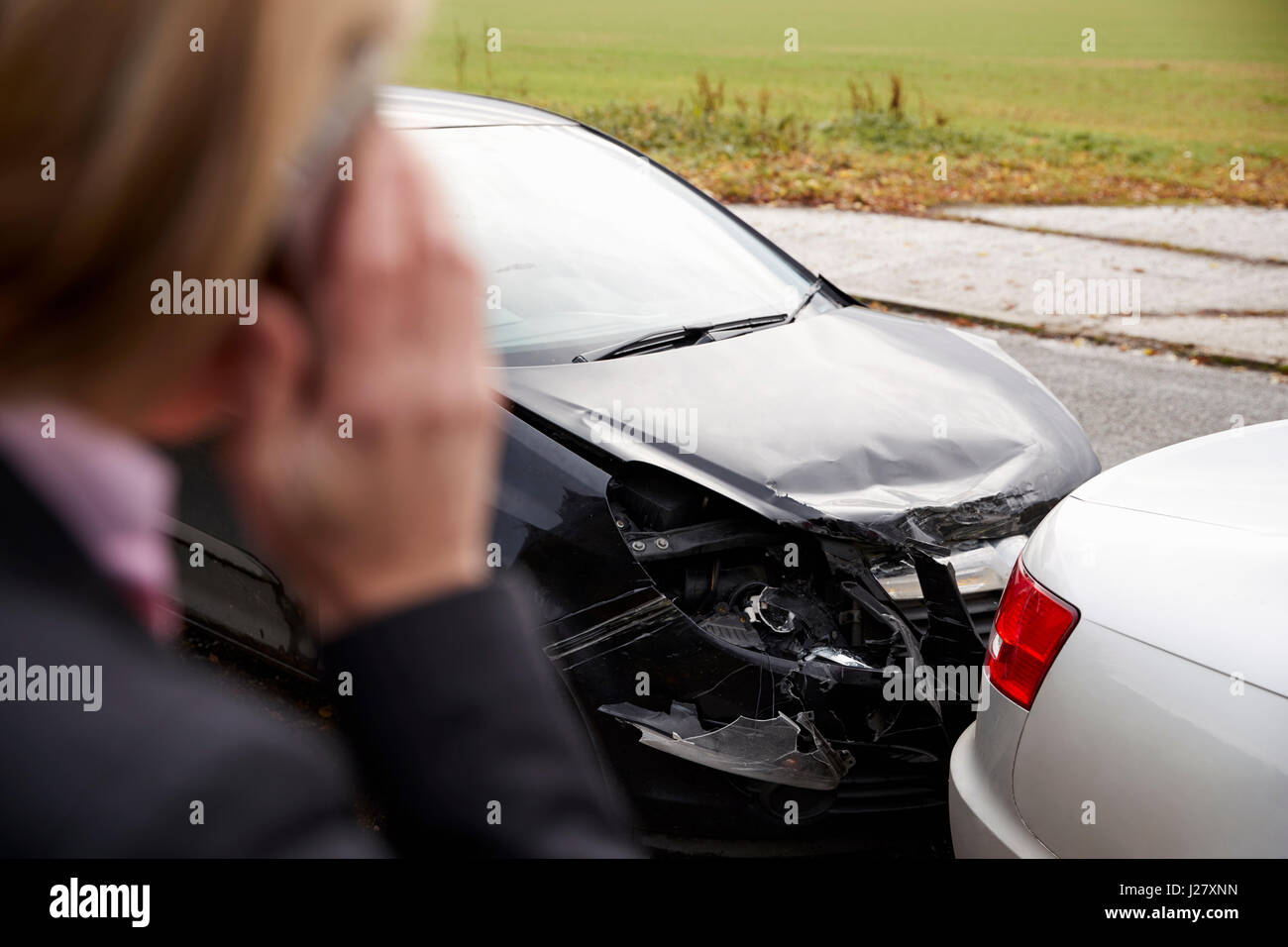 Donna che chiama alla relazione incidente di auto sulla strada di campagna Foto Stock