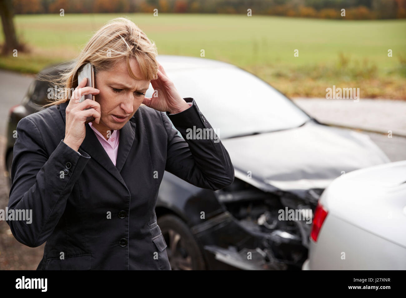 Donna che chiama alla relazione incidente di auto sulla strada di campagna Foto Stock