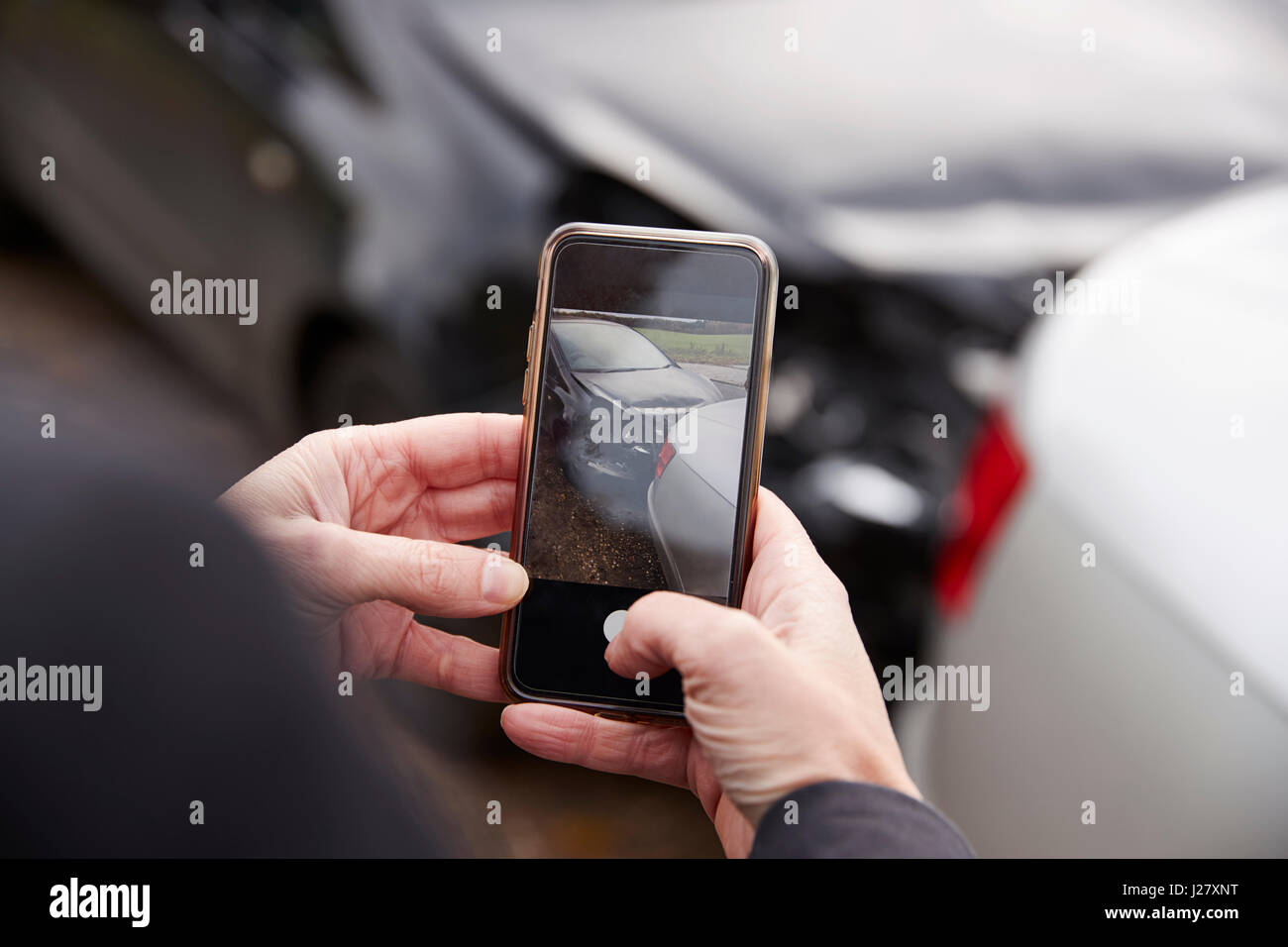 Donna prendendo foto di incidente stradale sul telefono cellulare Foto Stock