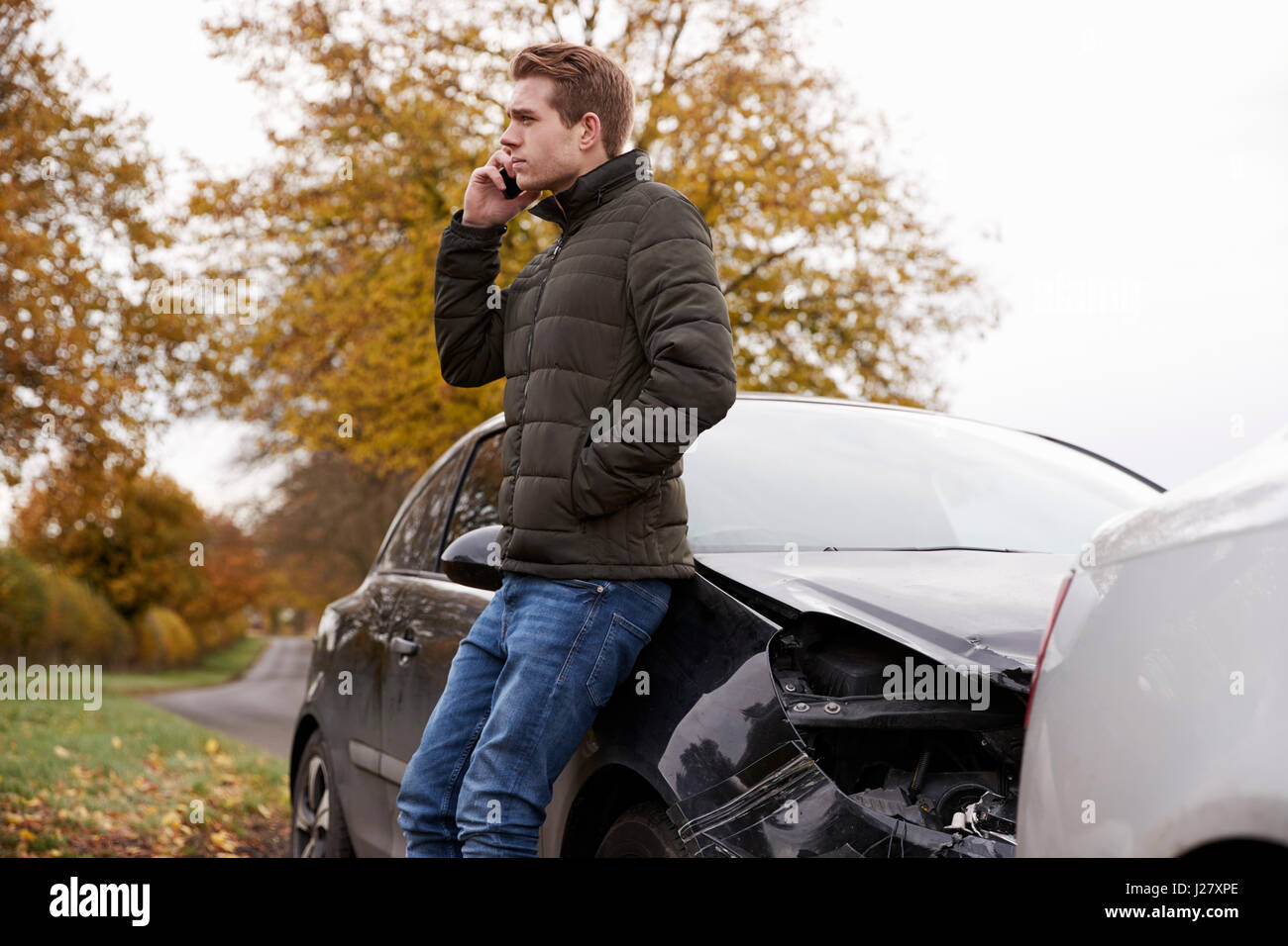 L'uomo chiamando per relazione incidente di auto sulla strada di campagna Foto Stock