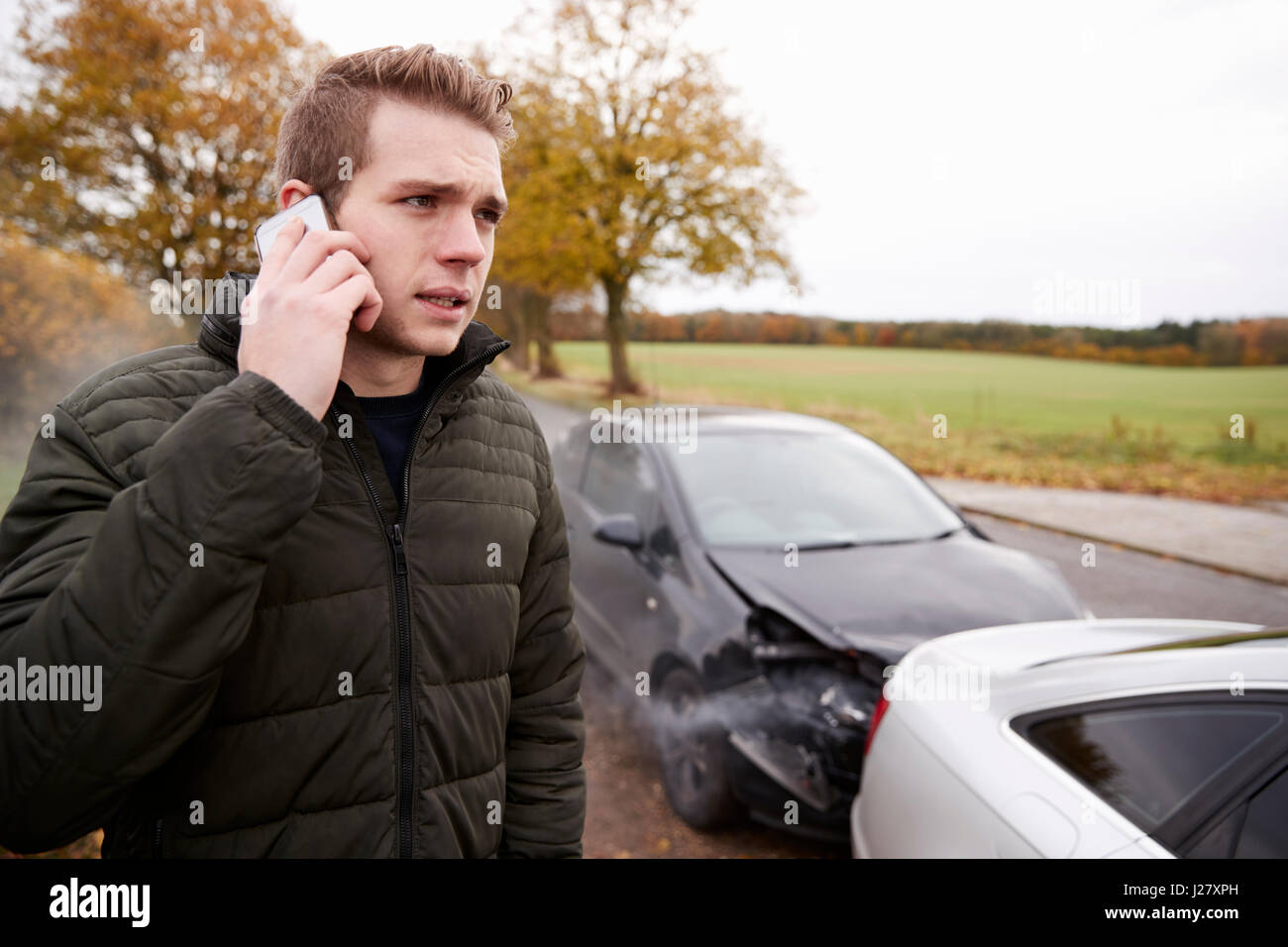 L'uomo chiamando per relazione incidente di auto sulla strada di campagna Foto Stock