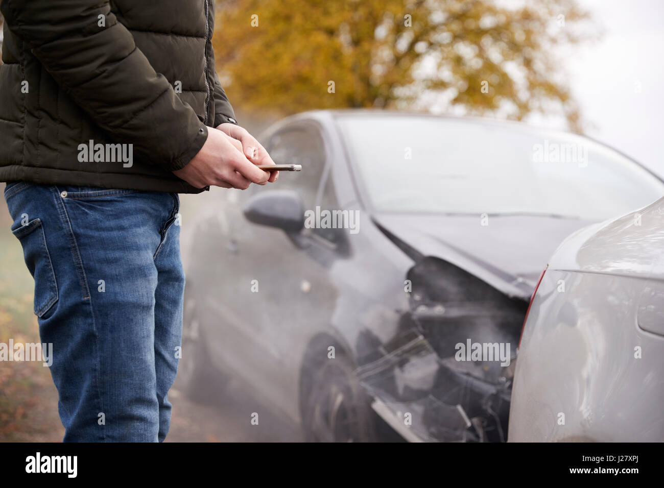 L'uomo chiamando per relazione incidente di auto sulla strada di campagna Foto Stock