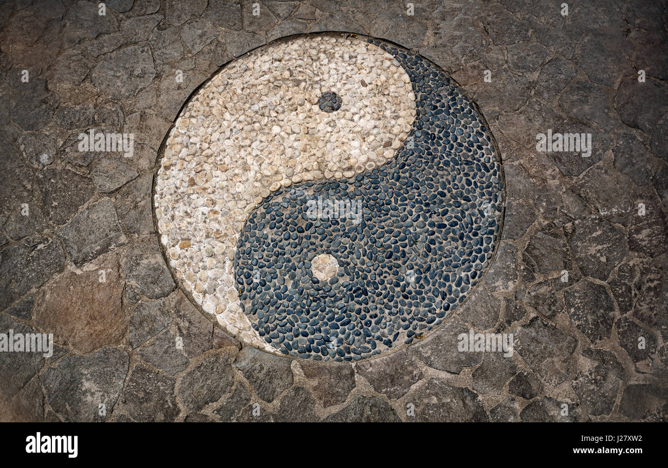 Yin Yang simbolo in mosaico pavimento in pietra Foto Stock