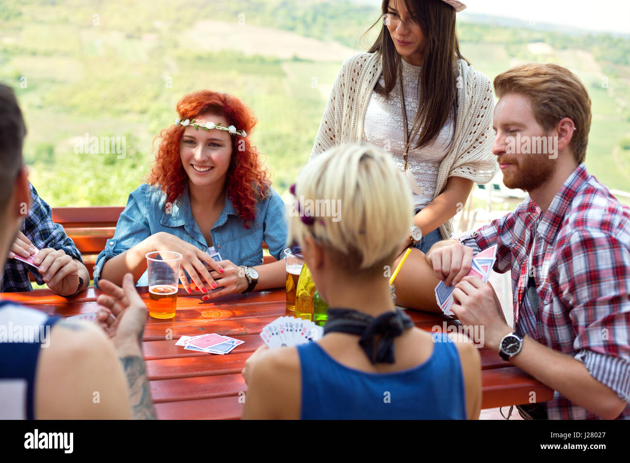 Allegro giovani sono perfettamente avendo divertimento mentre si beve birra e gioca card in natura Foto Stock