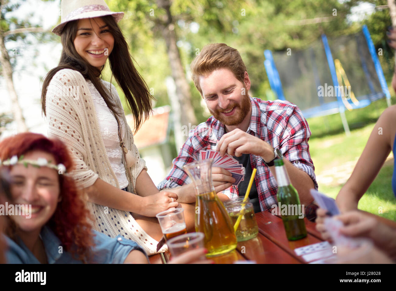 Allegro giovani sono perfettamente avendo divertimento mentre si beve birra e gioca card in natura Foto Stock