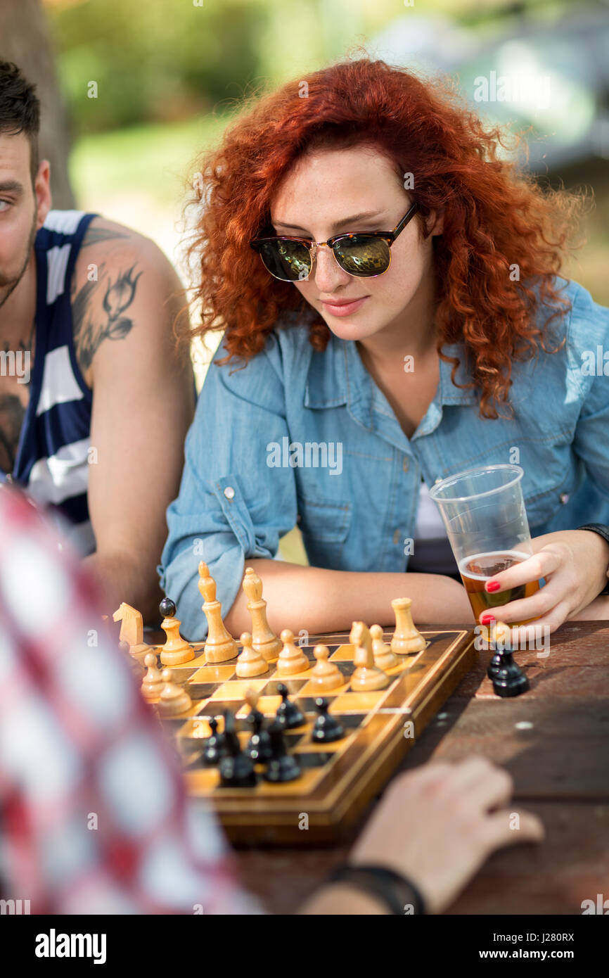 Giovane femmina ricci giocare a scacchi al Summer Camp in foresta Foto Stock