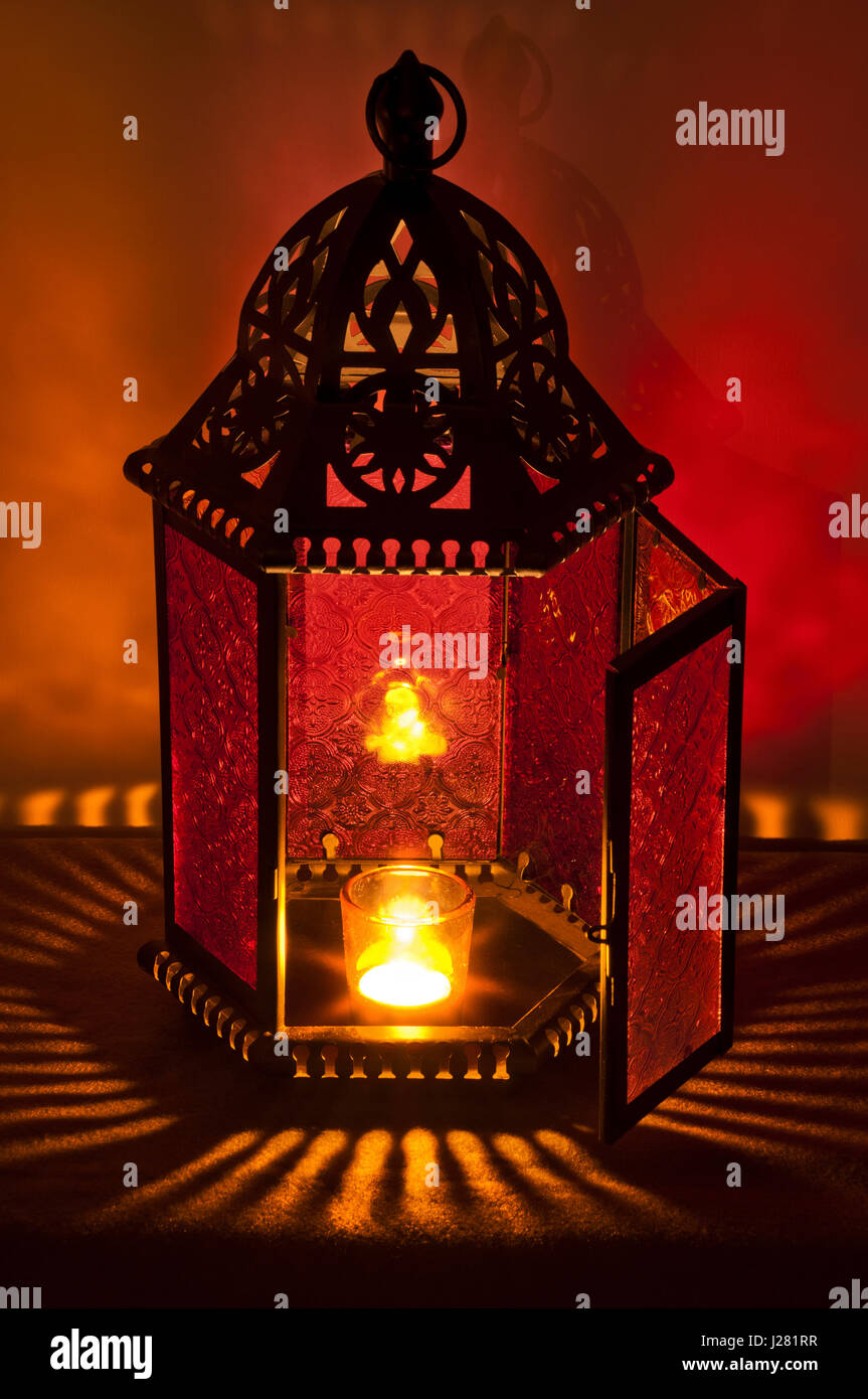 Metallo Lanterna Vintage illuminato a lume di candela con profondi colori rosso e oro Foto Stock