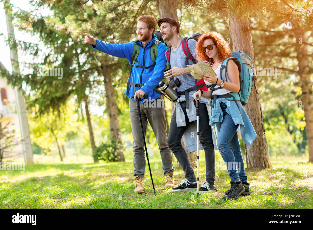 I giovani leader del gruppo di escursionisti mostra con le dita in modo foresta verde Foto Stock