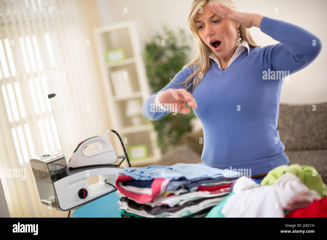Desperate Housewife pila di stiratura di camicie Foto Stock