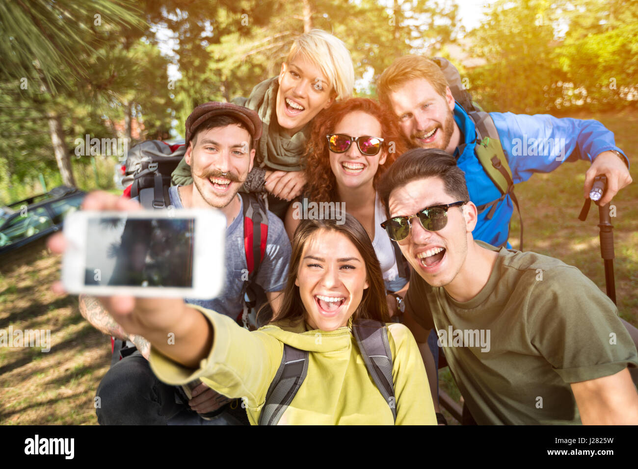 Allegro ragazze e ragazzi rende selfie nella foresta Foto Stock