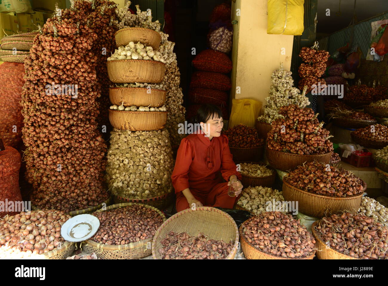 Un aglio, la cipolla e lo scalogno venditore in Hanoi il mercato centrale. Foto Stock