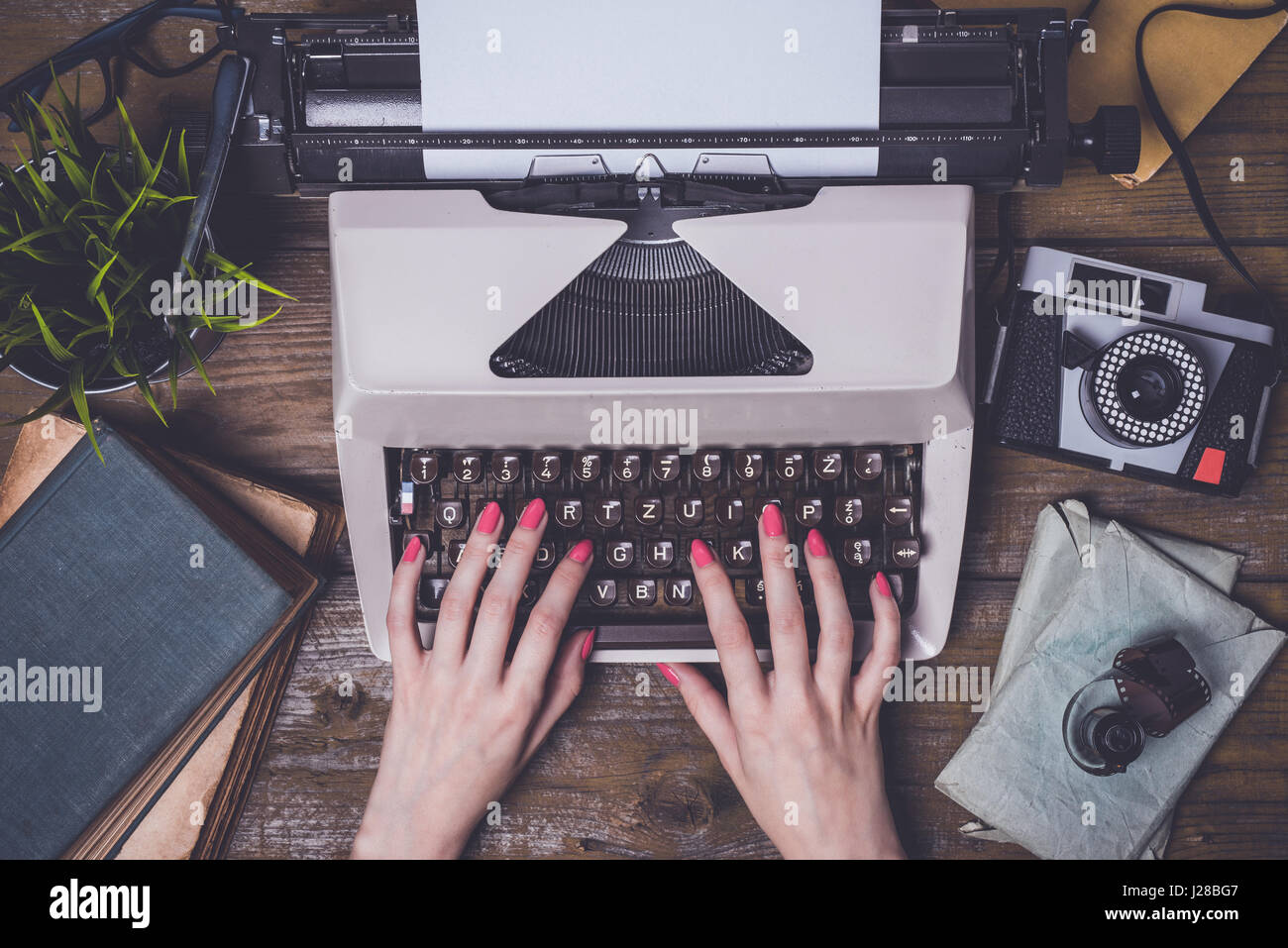 Mani femminili la scrittura su una vecchia macchina da scrivere Foto Stock