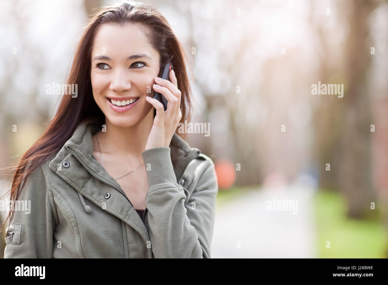 Un colpo di un etnica studente parlando al telefono Foto Stock
