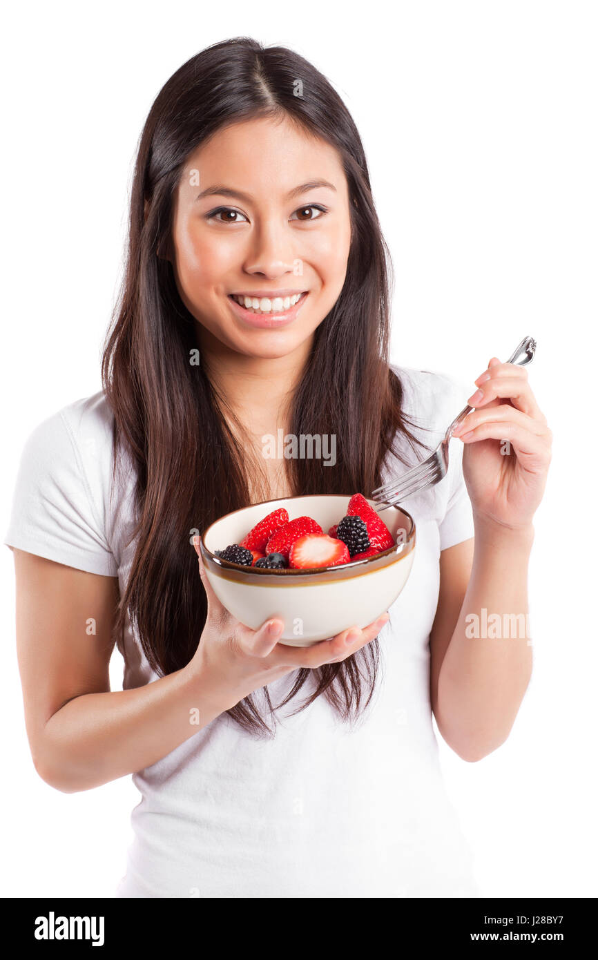 Un colpo isolato di una donna asiatica tenendo una ciotola di frutta Foto Stock