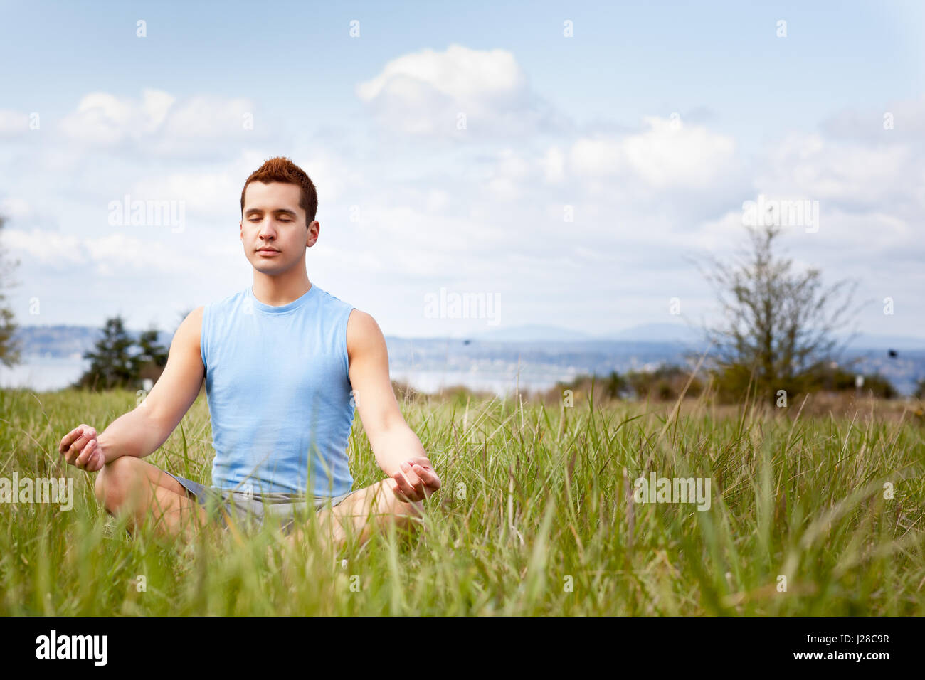 Un colpo di una razza mista uomo a praticare yoga outdoor Foto Stock