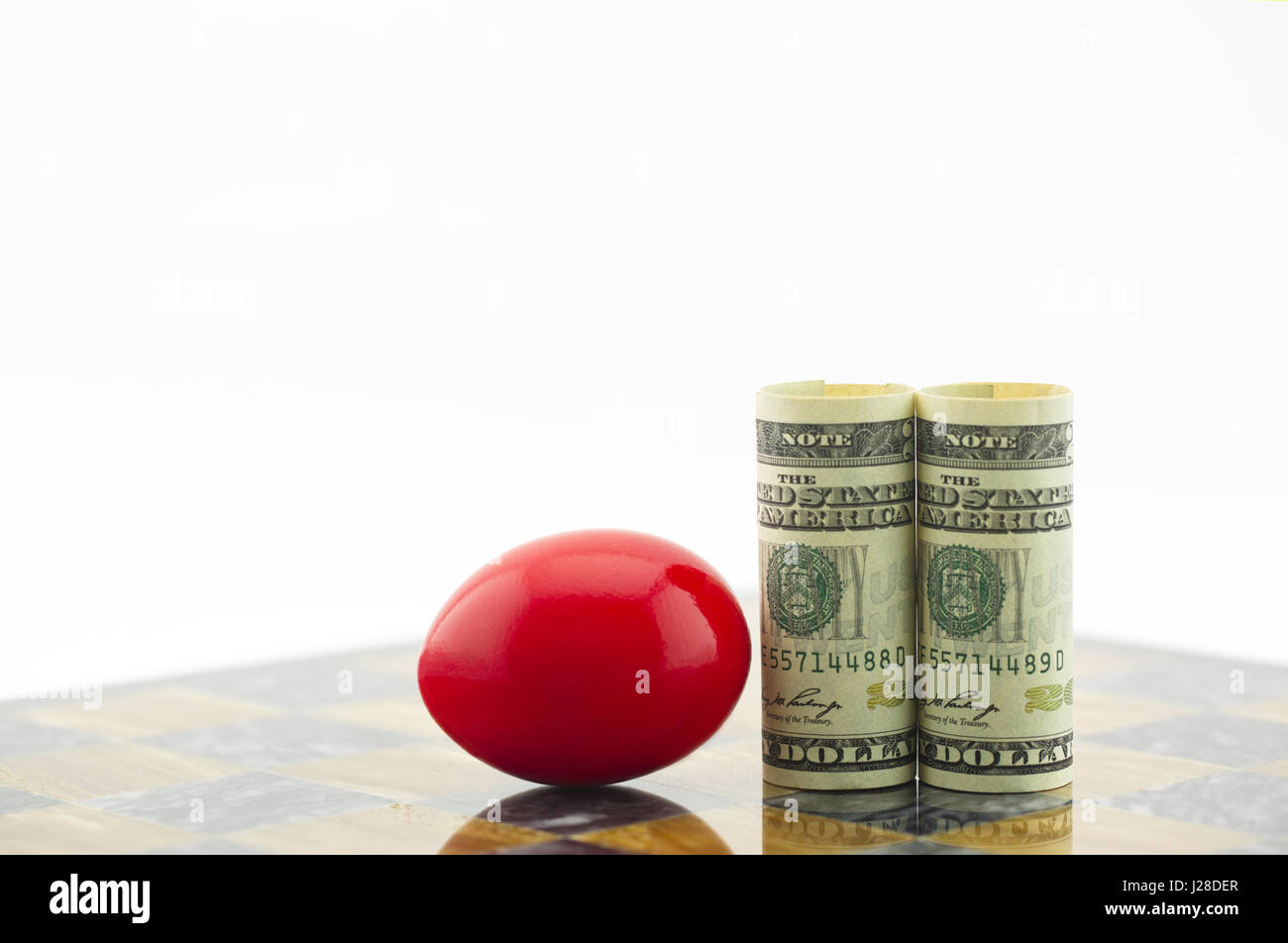 Red nest uovo e il dollaro americano la valuta utilizzata a bordo del gioco. Simboli riflettere il rischio di business e il fallimento finanziario degli investimenti. Foto Stock