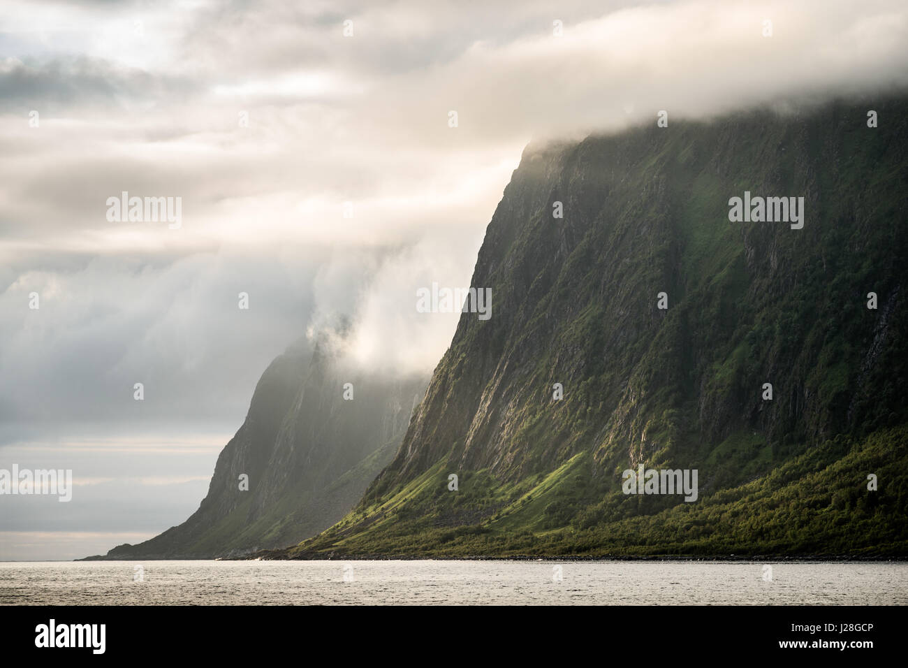 Norvegia, Troms, montagne, veloce cambiamento modello nuvole le pareti di roccia in Ersfjord Foto Stock
