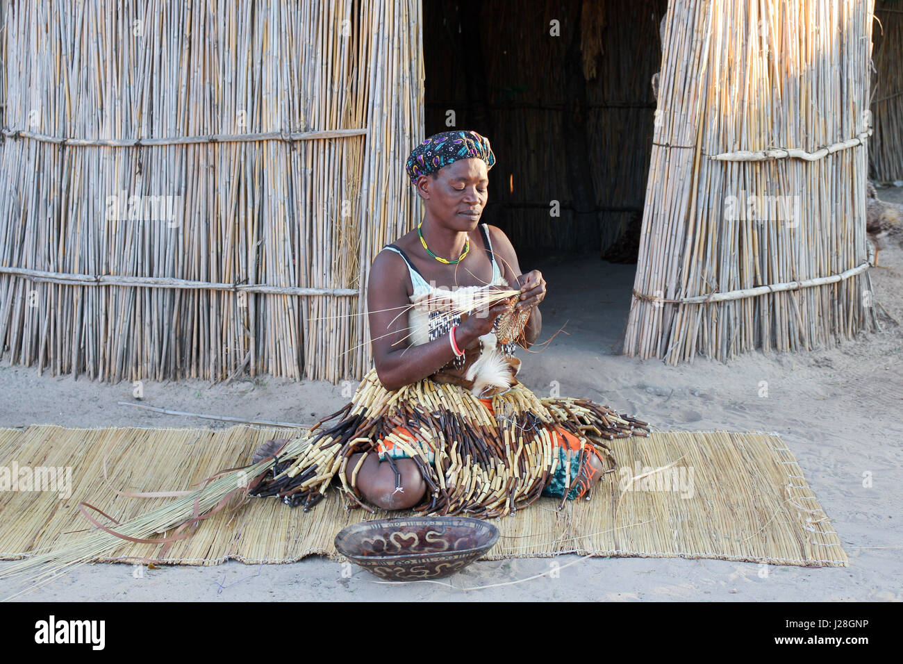 La Namibia, Caprivi Strip, donna indigena in trecciatura, manifatture in show village Foto Stock