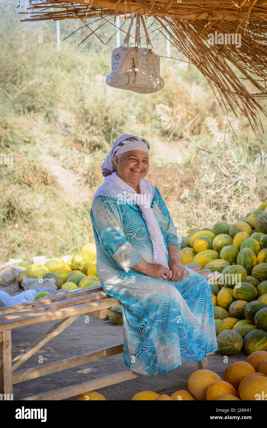 Uzbekistan, Buxoro Provincia, Jondor tumani, sul ciglio della strada ci sono molti commercianti di melone. Qui la donna ha il dire Foto Stock