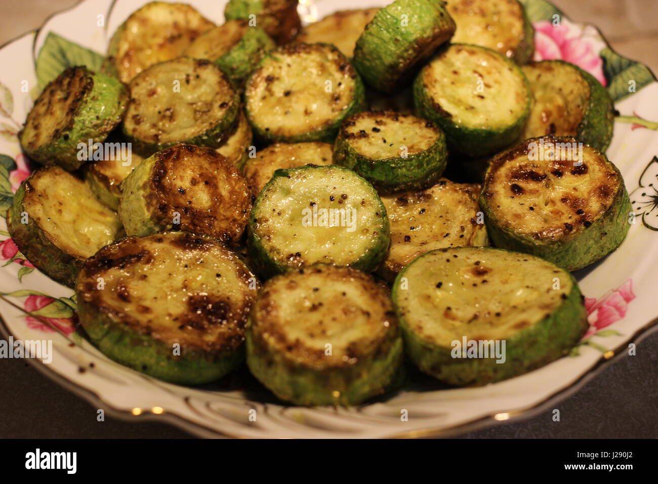 Zucchine fritte con crosta sulla piastra Foto Stock