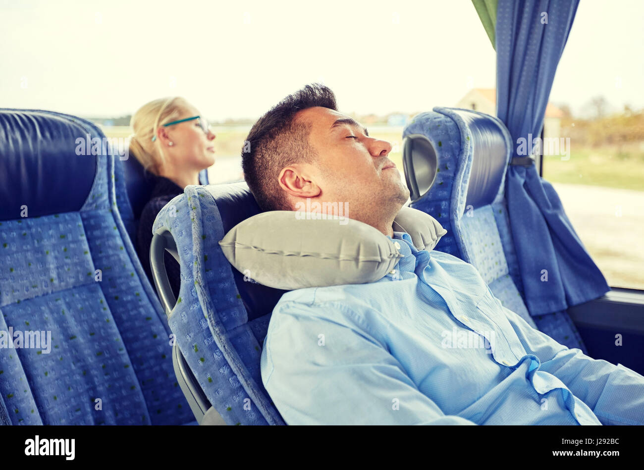 Uomo dorme in bus da viaggio con cuscino cervicale Foto stock - Alamy