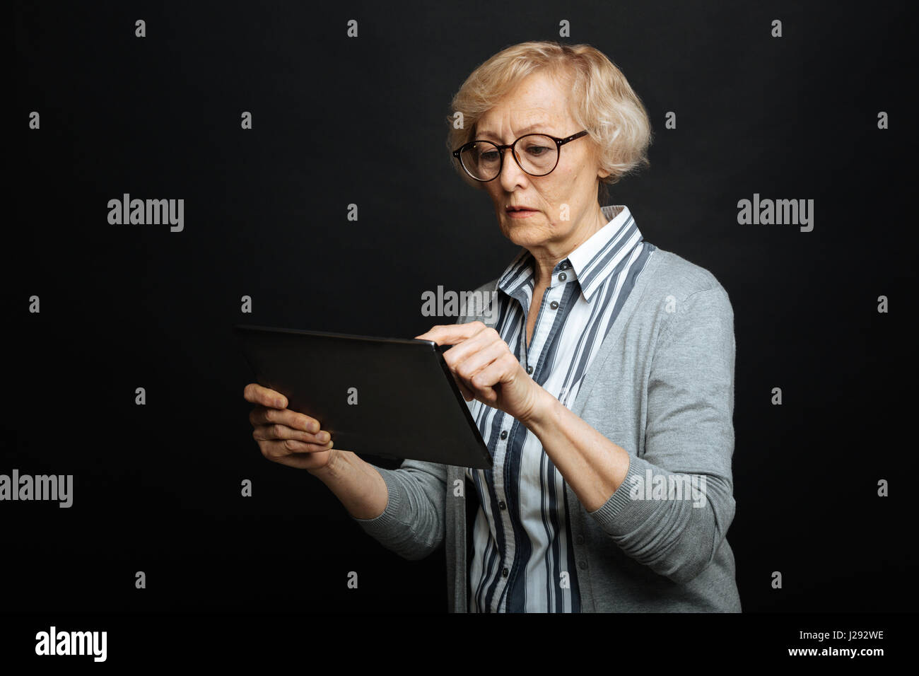 Coinvolto in pensione donna utilizzando tablet in studio Foto Stock