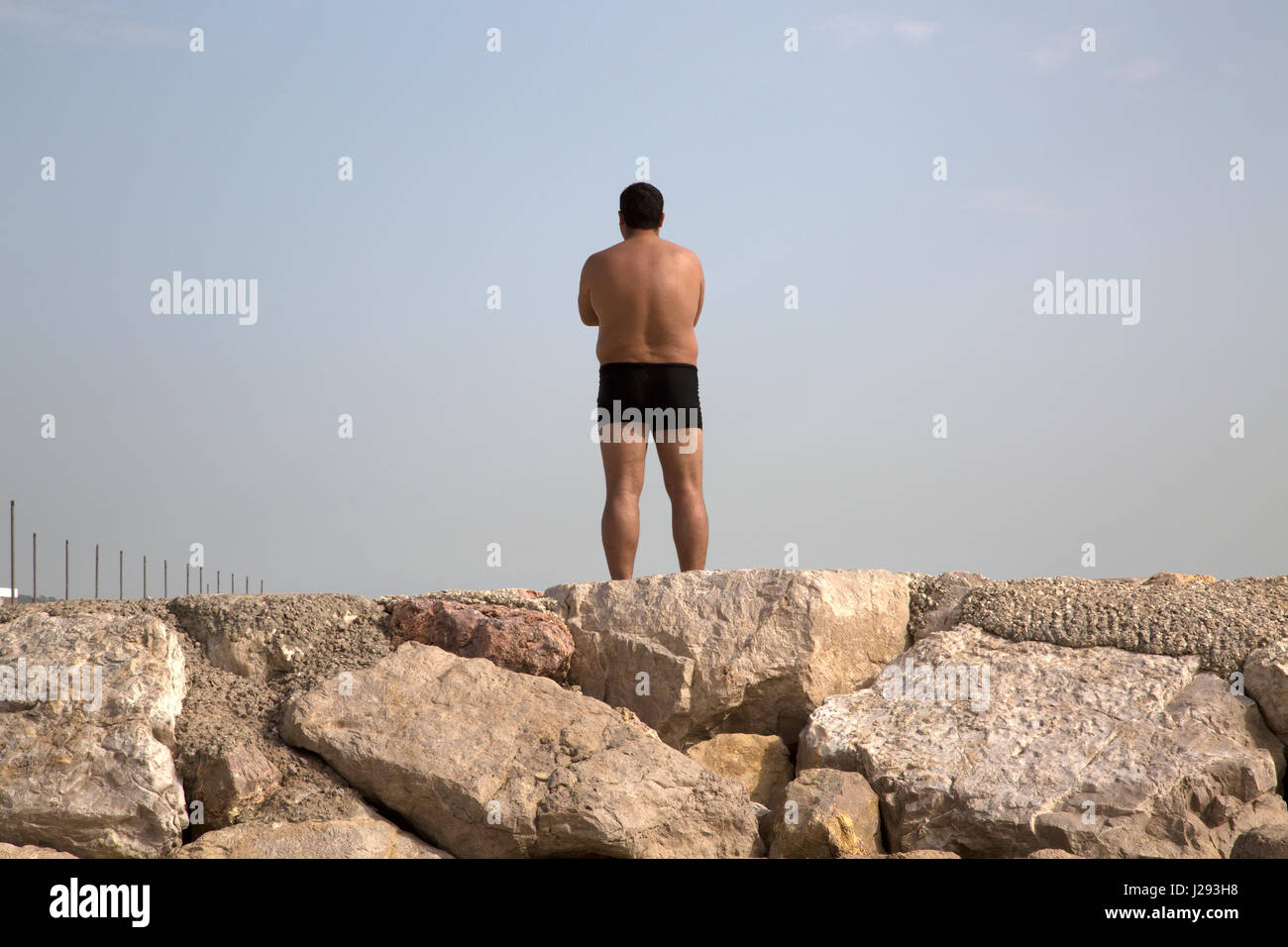 Un uomo in pantaloncini corti a Cascais Beach, Portogallo. Foto Stock
