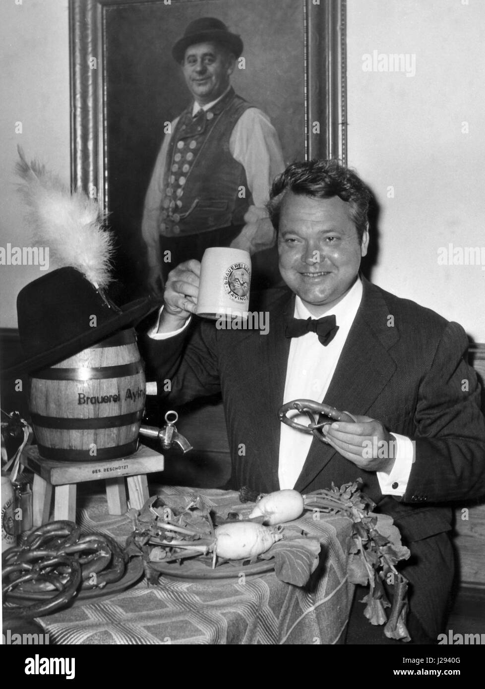 American regista e attore Orson Welles jabs a tre litri-canna presso il ristorante 'Am Platz I' a Monaco di Baviera, Germania) il 5 maggio 1954. Welles era attualmente riprese a Monaco di Baviera. | Utilizzo di tutto il mondo Foto Stock