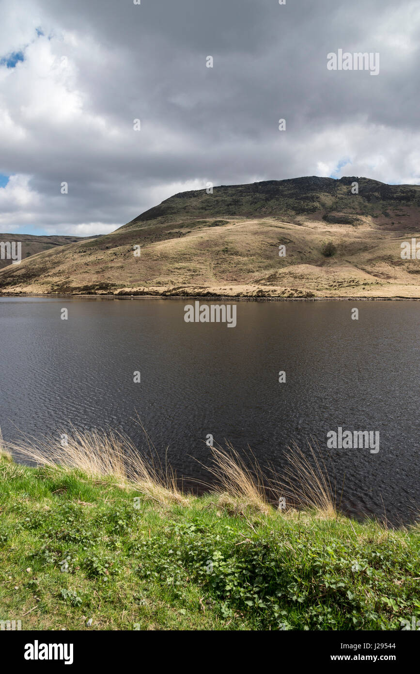 Vista delle colline in tutta l'acqua a Yeoman Hey serbatoio vicino Greenfield, Greater Manchester, Inghilterra. Foto Stock