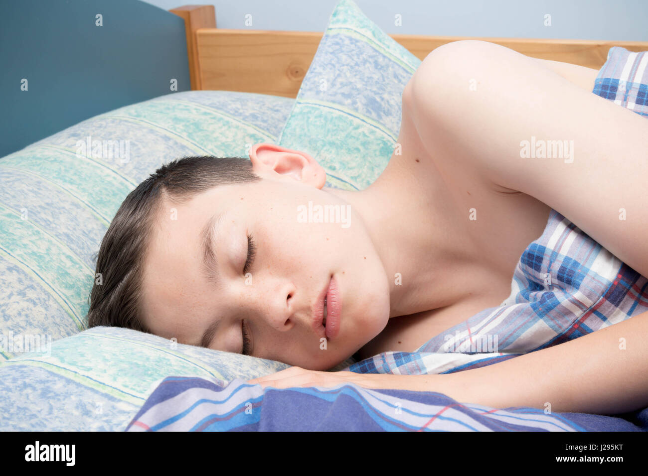 Giovani caucasici ragazzo adolescente addormentato nel suo letto Foto Stock