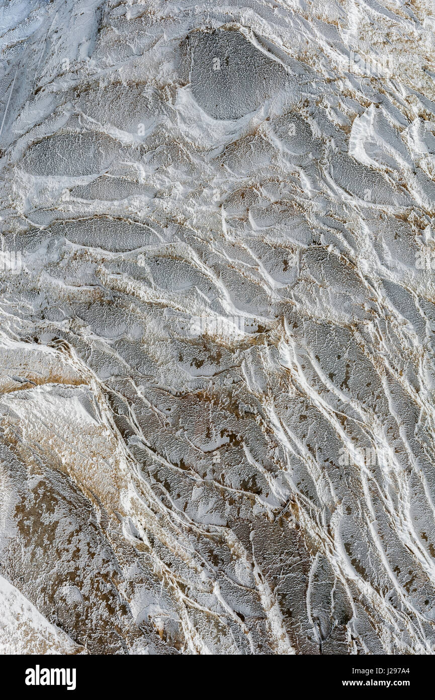 I cristalli di ghiaccio e la superficie trasformata per forte gradiente formato da congelare durante la notte su alta alpine rockface d'inverno. Foto Stock