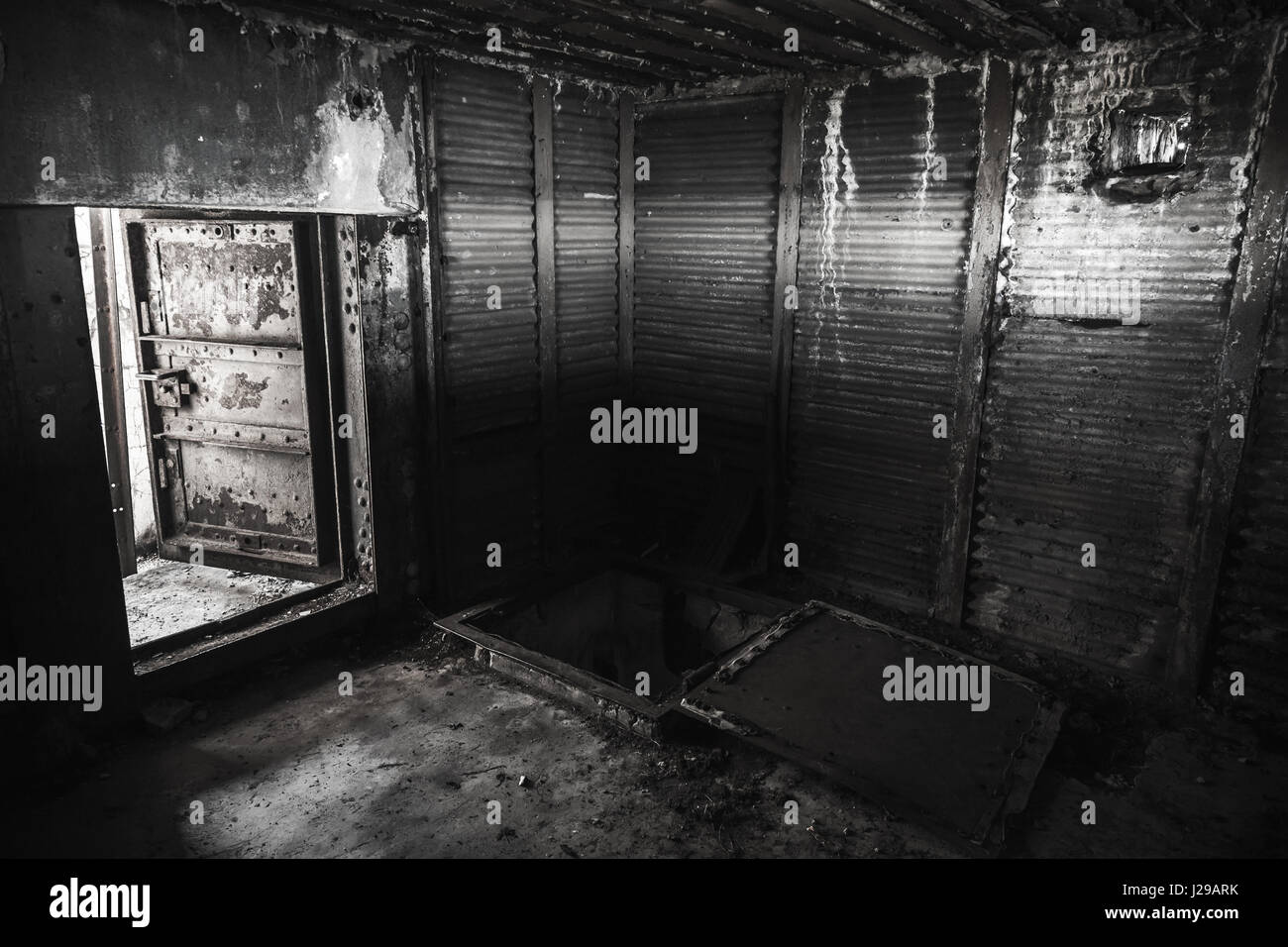 Abstract dark grungy industrial interior con pareti metalliche e aprire la pesante porta di acciaio, in bianco e nero Foto Stock