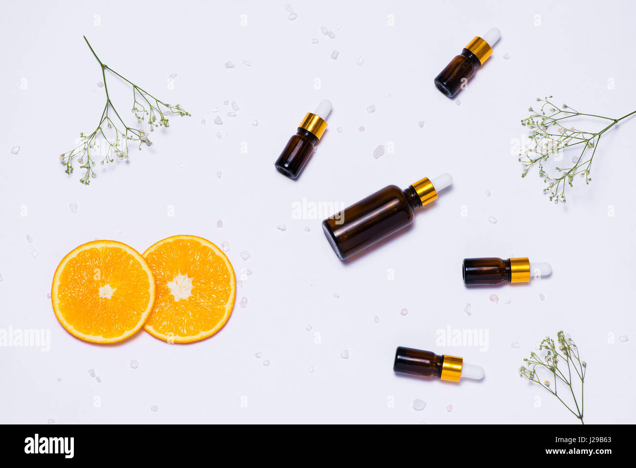 Il Branding mock-up. Olio essenziale naturale, bottiglia di cosmetici contenitori con fettine di arancia. Foto Stock