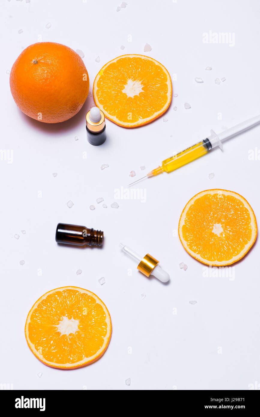 Il Branding mock-up. Olio essenziale naturale, bottiglia di cosmetici contenitori con fettine di arancia. Foto Stock